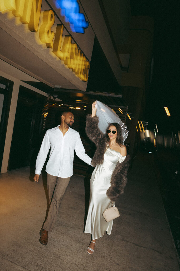 Katie and Karl’s late-night San Diego engagement session was absolutely the latter. These two showed up ready for fun, dressed to the nines, and totally embracing that after-dark, moody, editorial vibe that downtown does so well. It was fashion, flash, and pure personality—exactly what makes nighttime engagement photos so electric. 