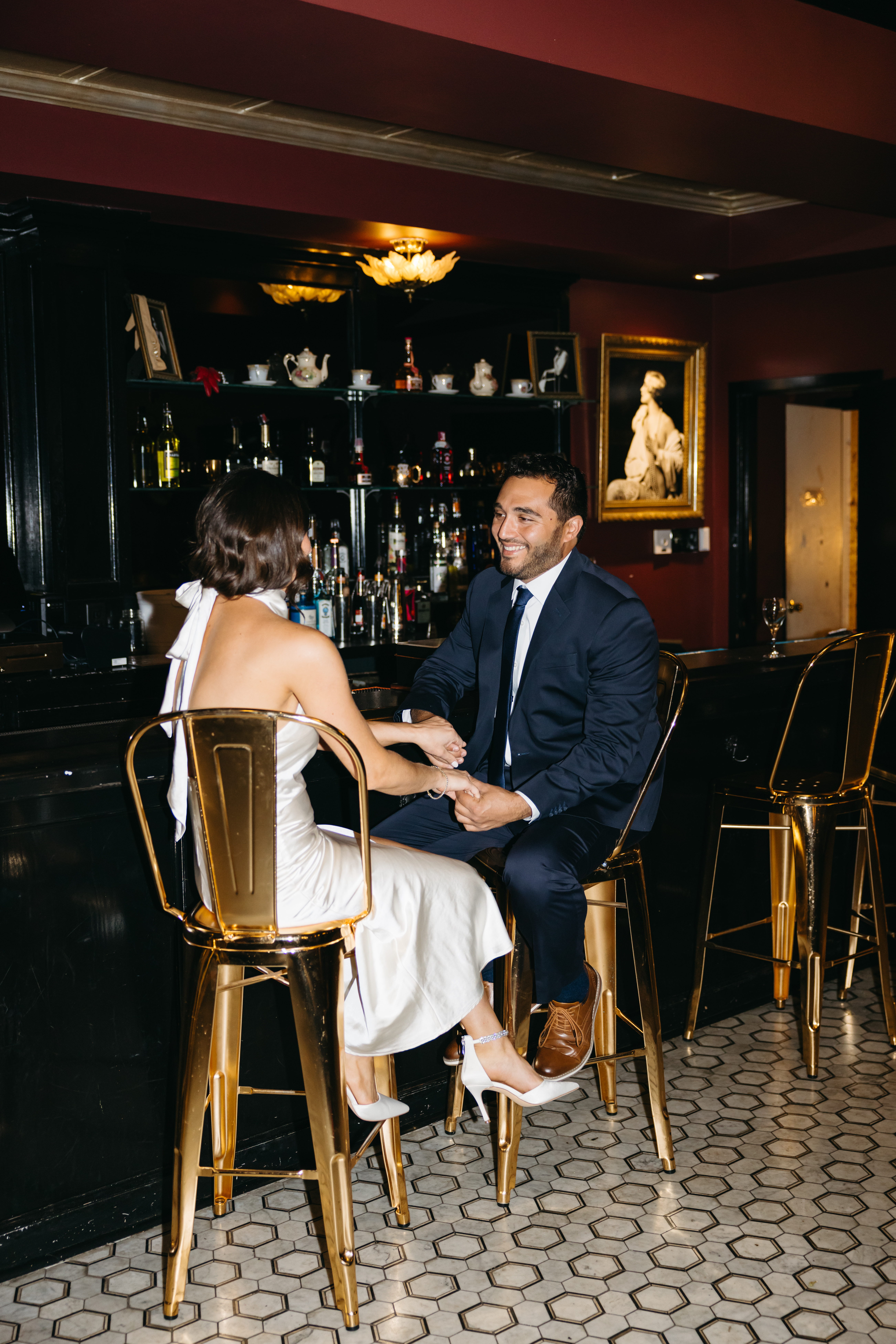 Couple sitting at a dimly lit bar sharing drinks during engagement session in Scranton