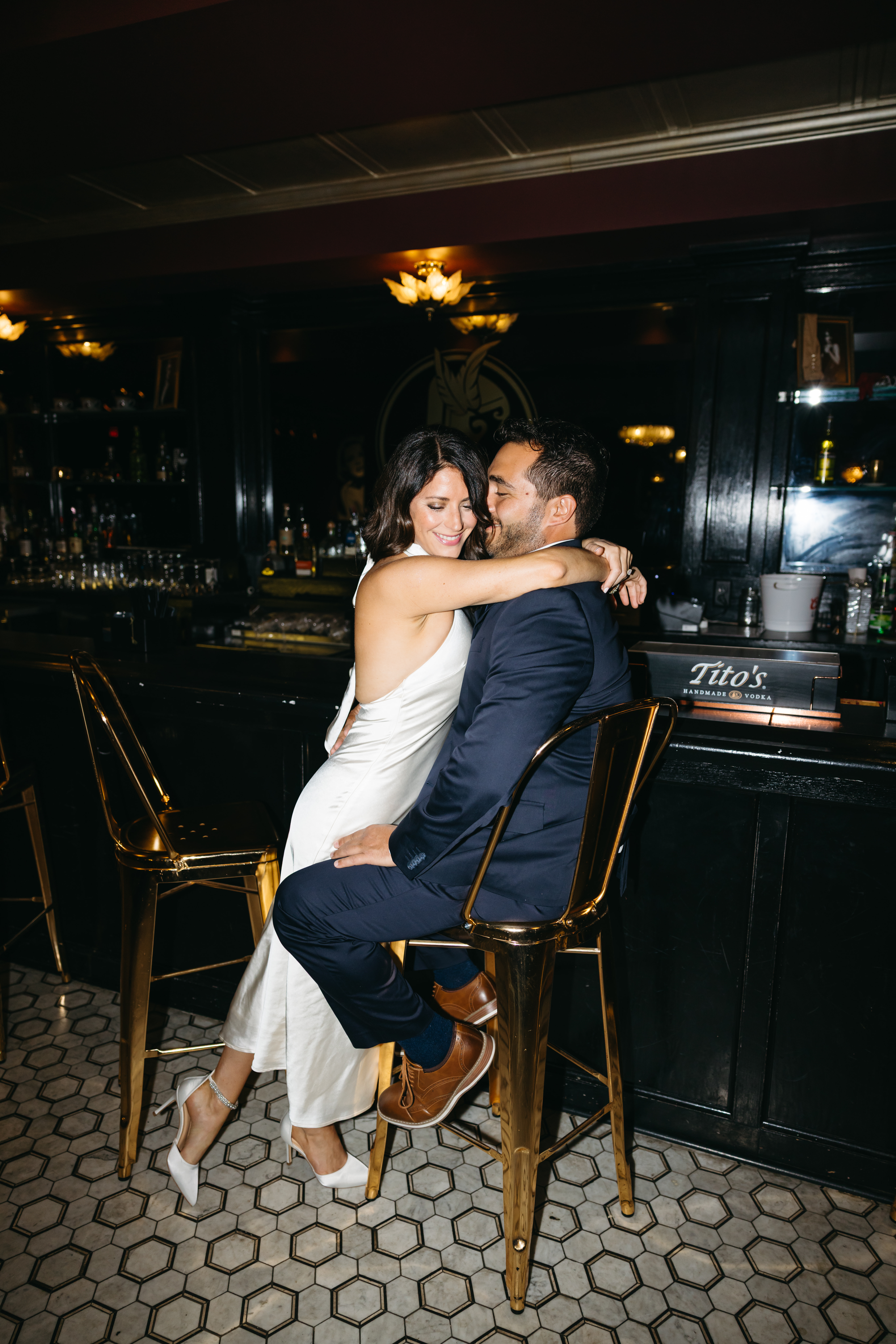 Couple sitting at a dimly lit bar sharing drinks during engagement session in Scranton