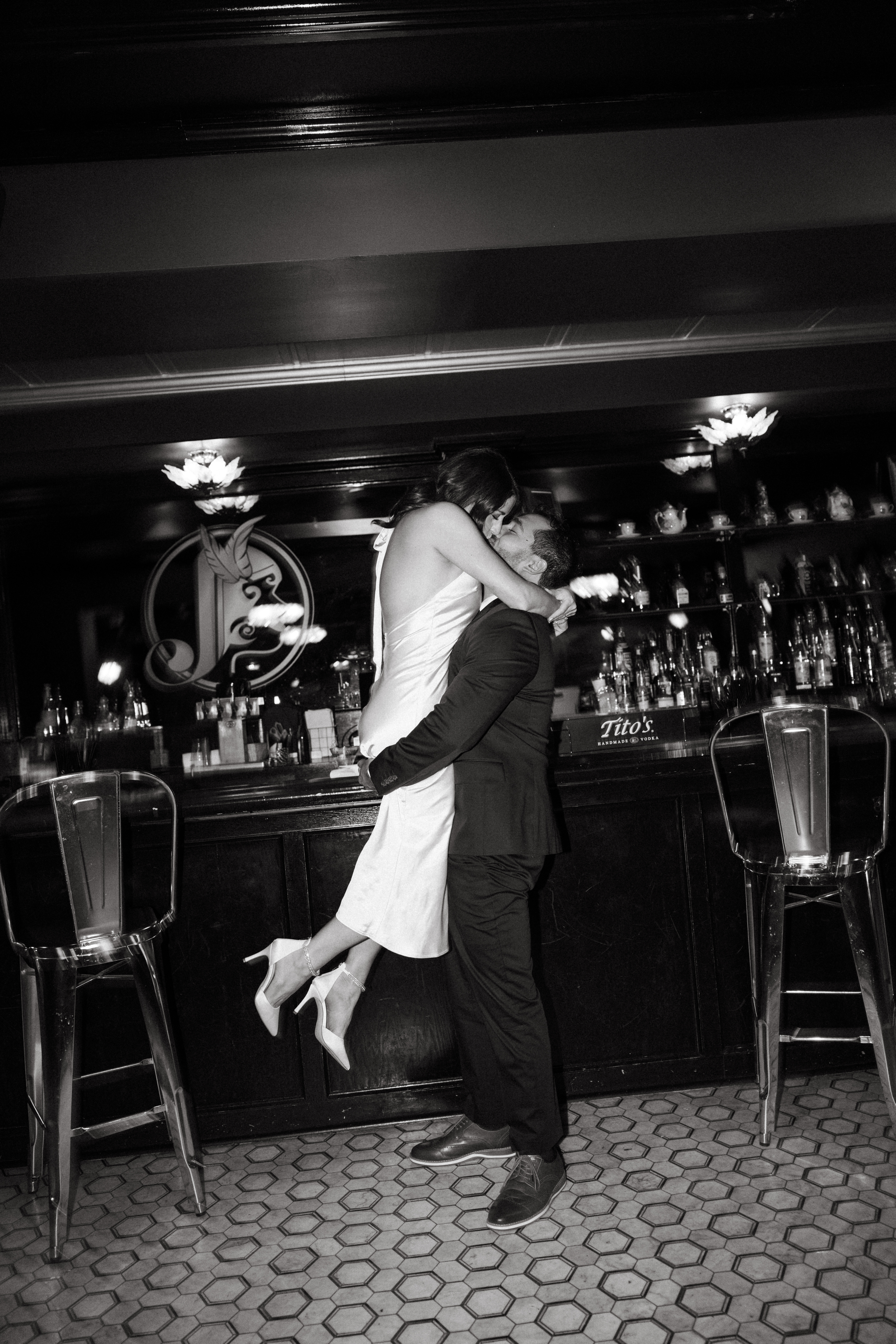 Couple sitting at a dimly lit bar sharing drinks during engagement session in Scranton