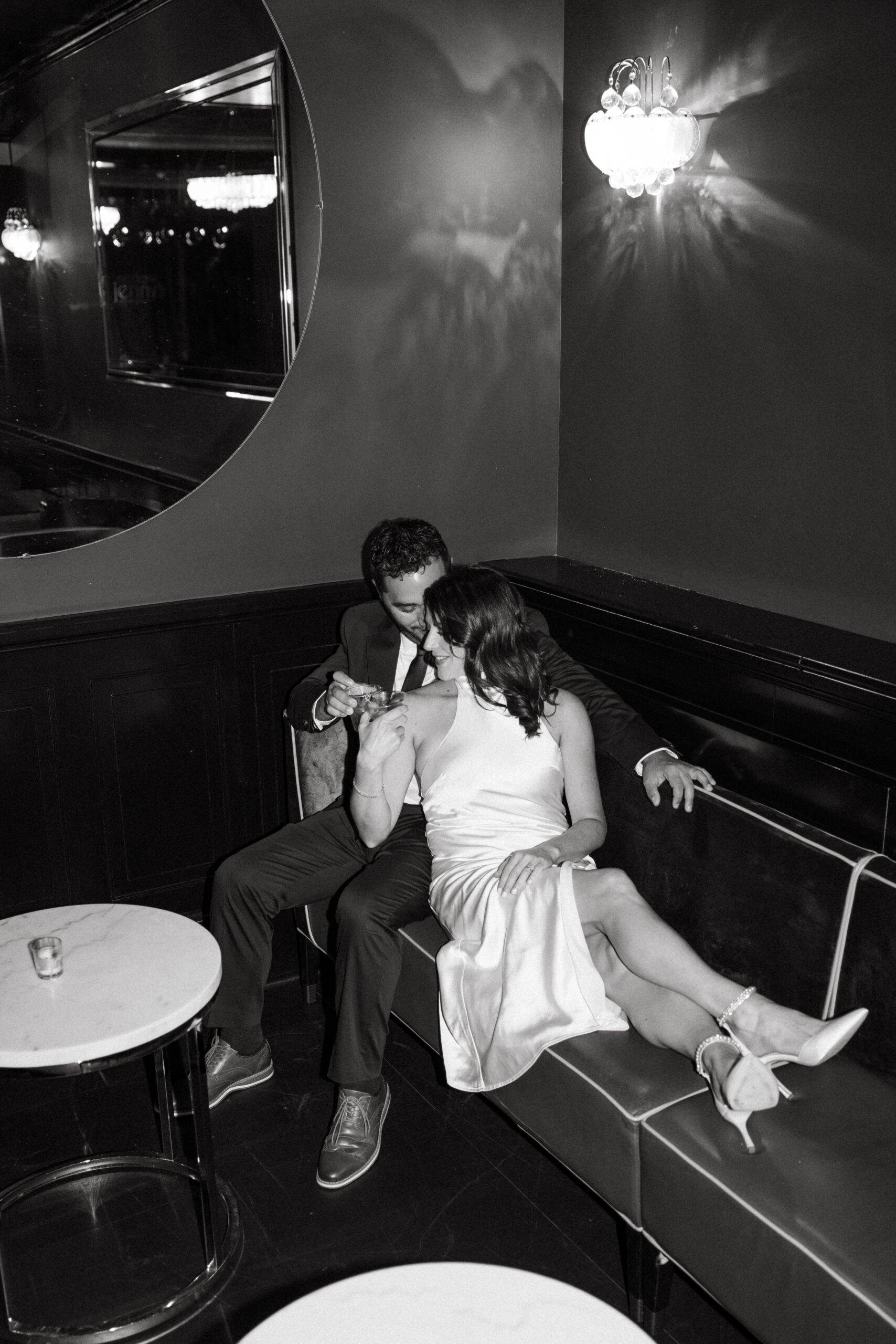 Couple sitting at a dimly lit bar sharing drinks during engagement session in Scranton