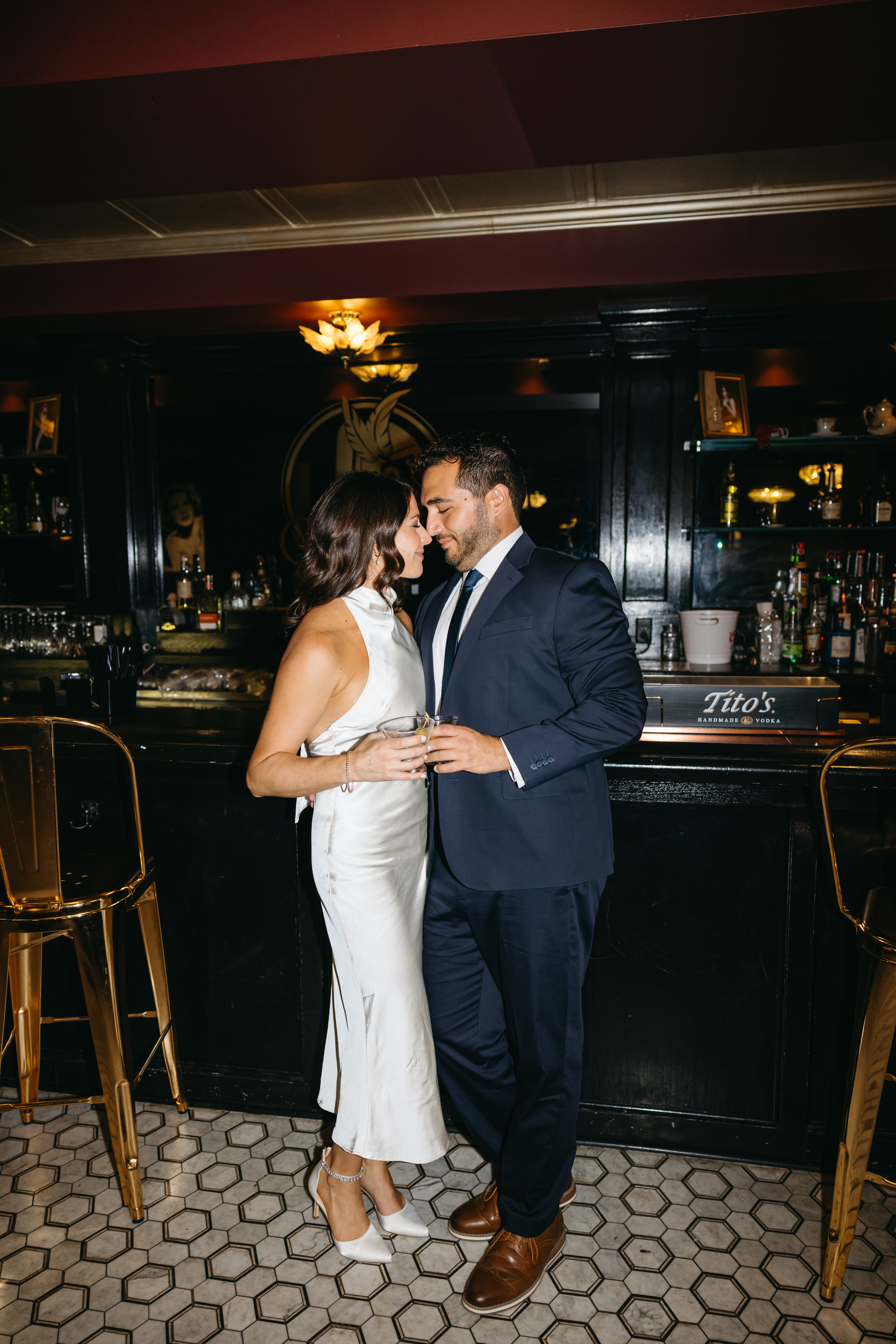 Couple sitting at a dimly lit bar sharing drinks during engagement session in Scranton