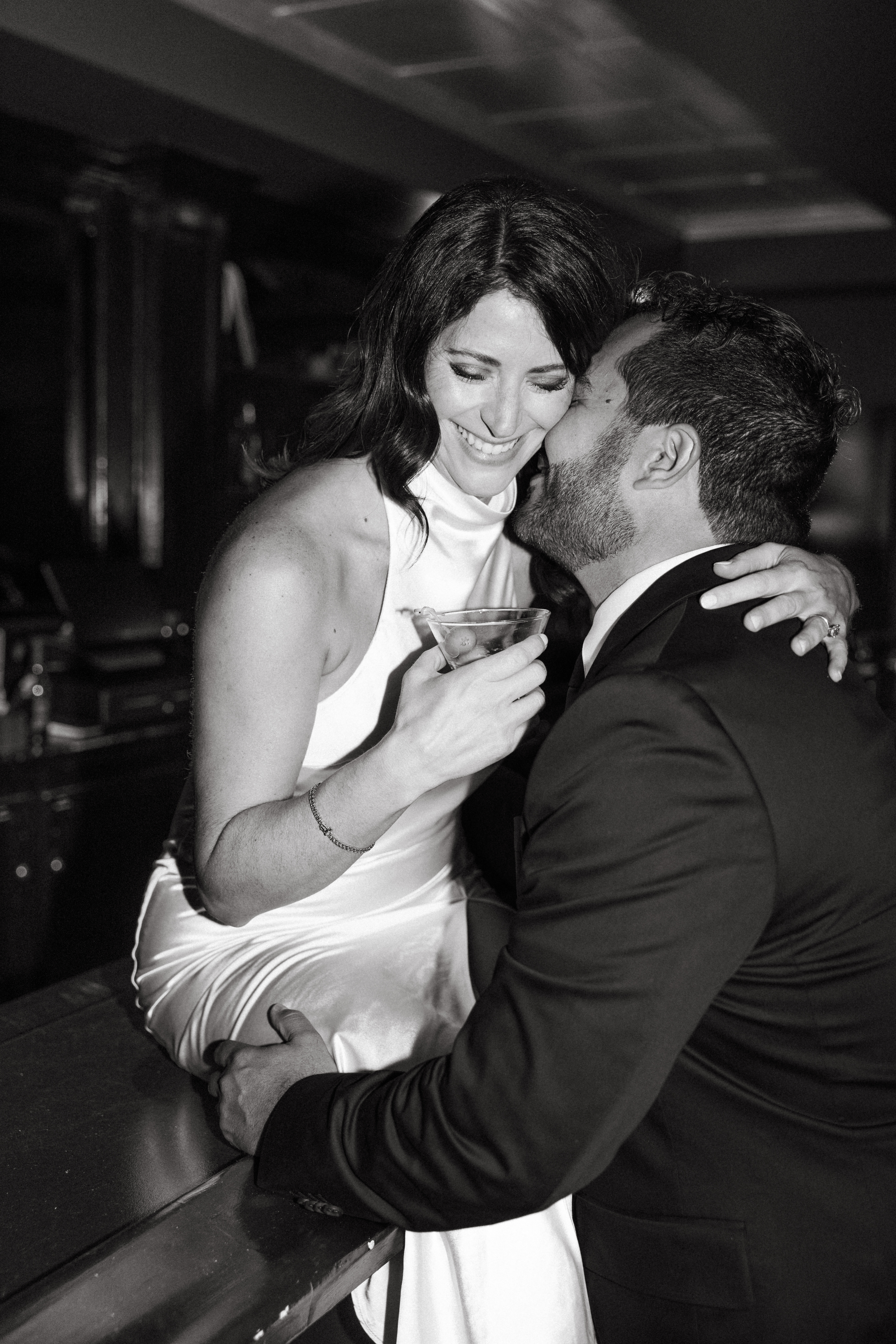Couple sitting at a dimly lit bar sharing drinks during engagement session in Scranton