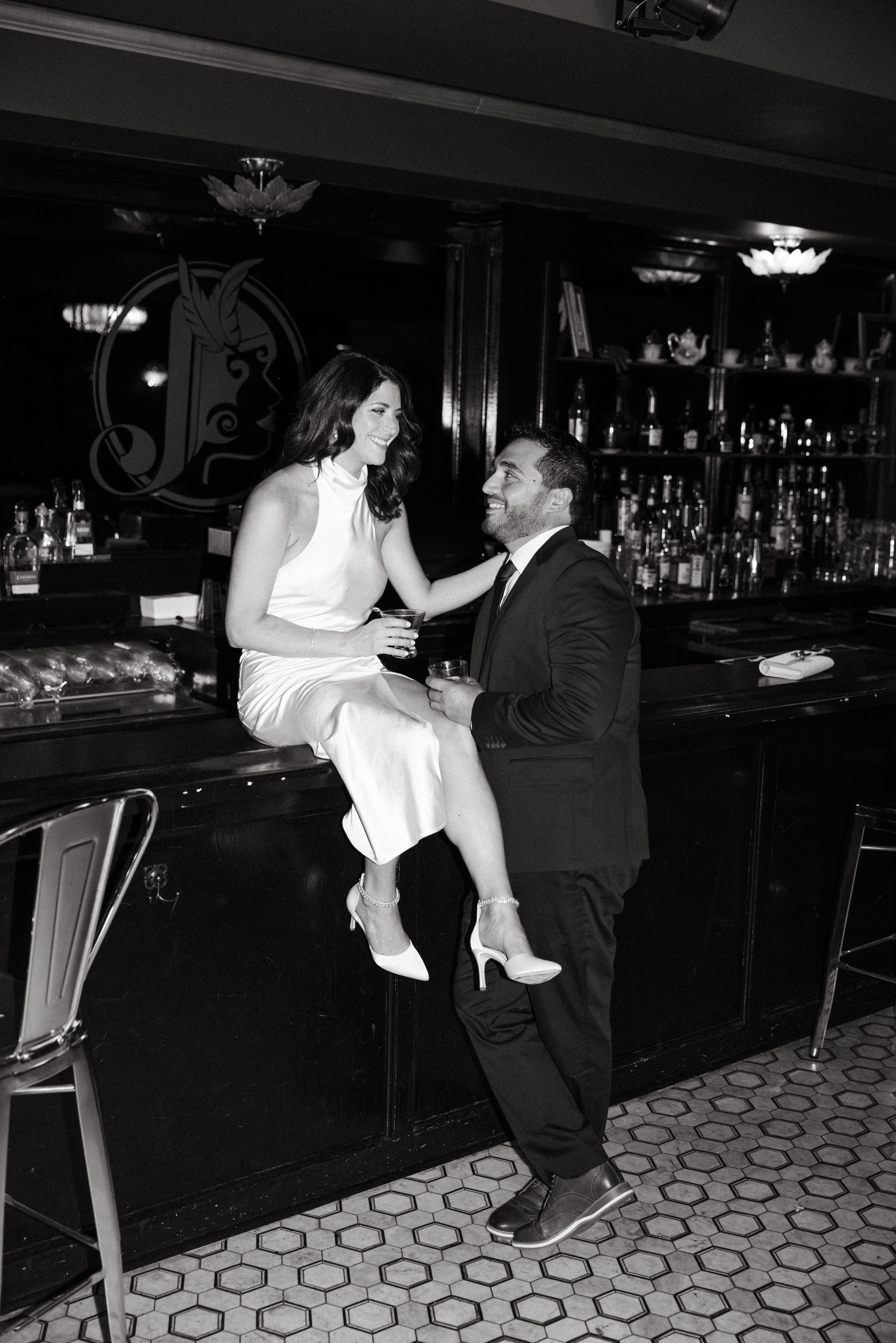 Couple sitting at a dimly lit bar sharing drinks during engagement session in Scranton