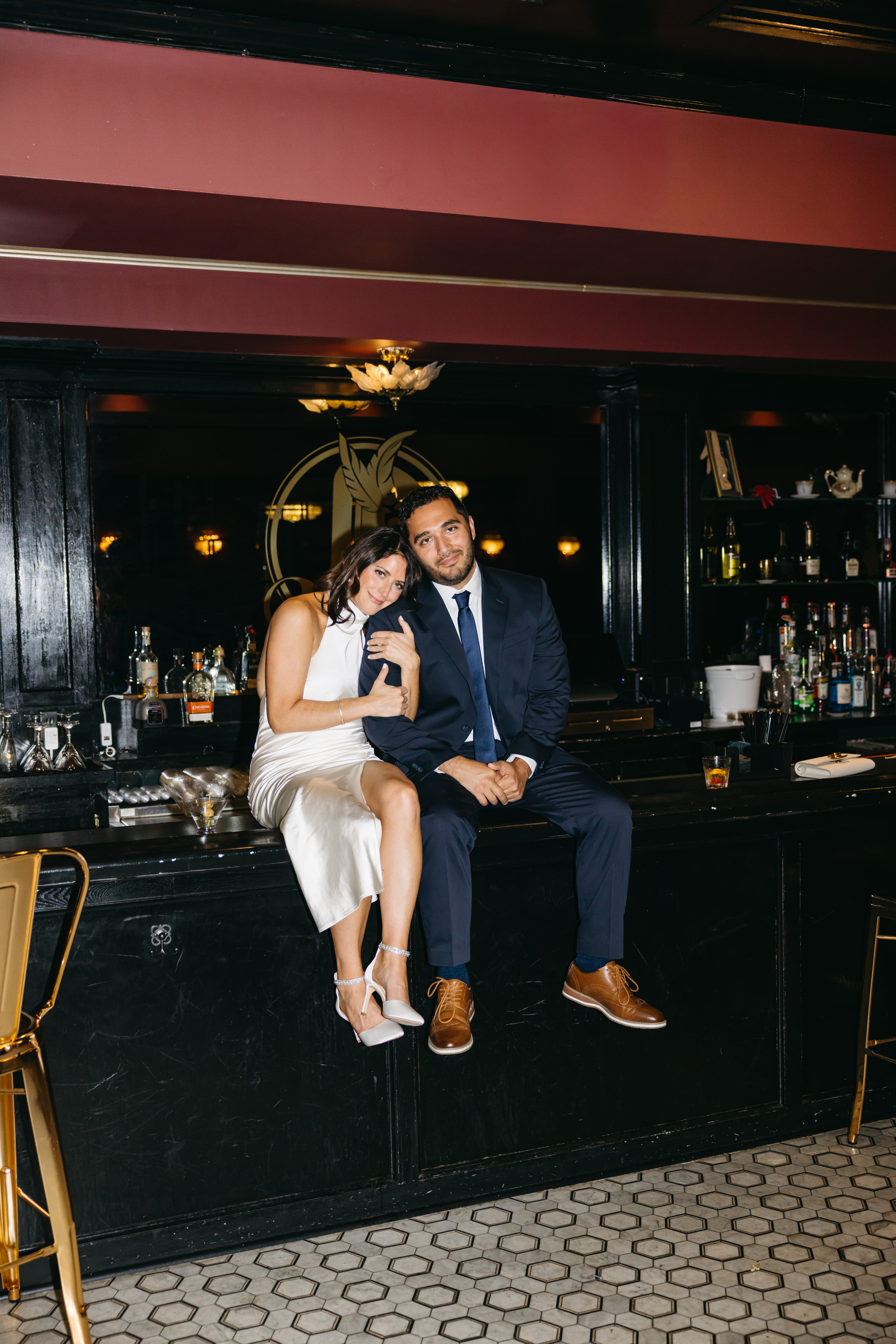 Couple sitting at a dimly lit bar sharing drinks during engagement session in Scranton