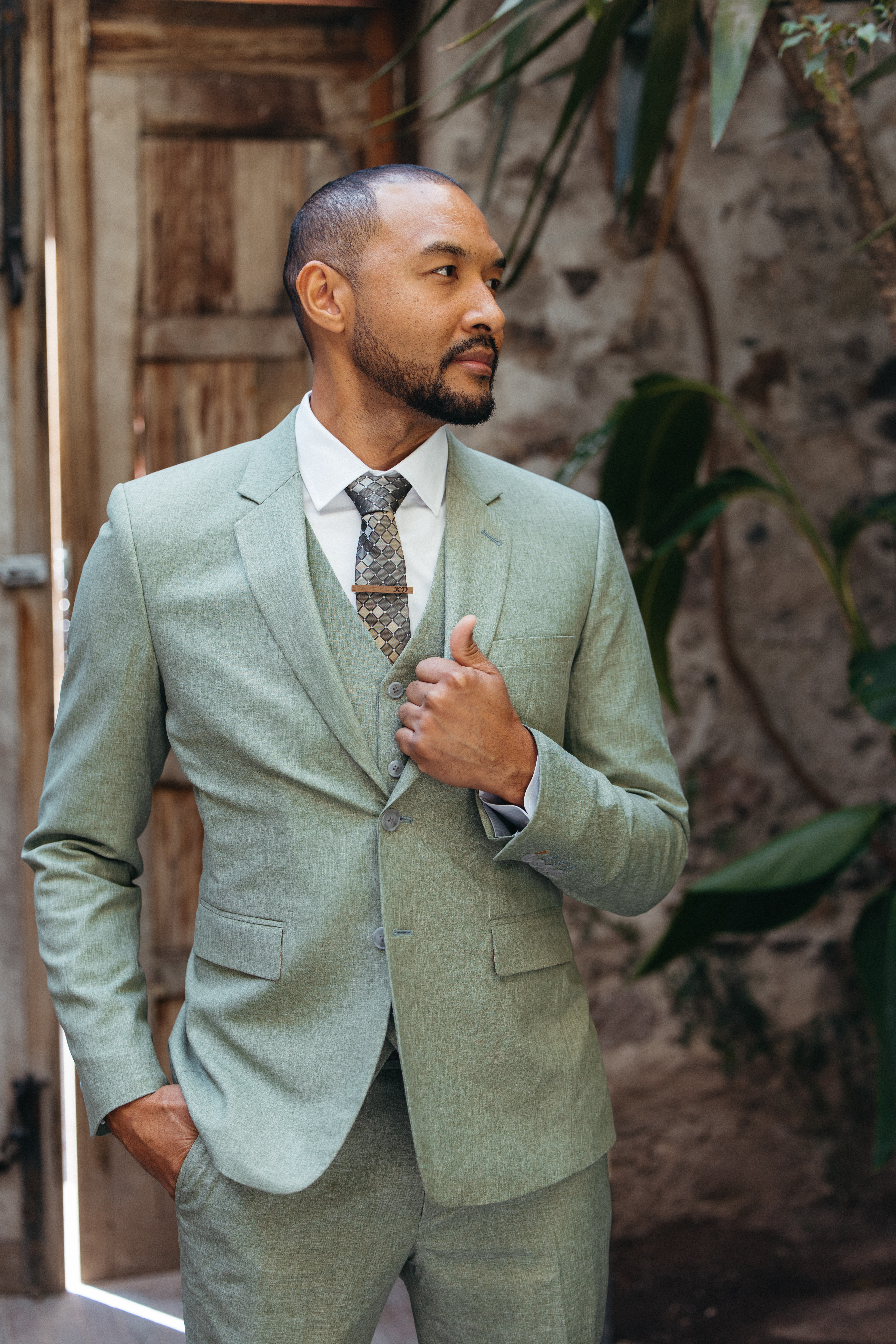 Groom adjusting his suit while spending time with family before the ceremony
