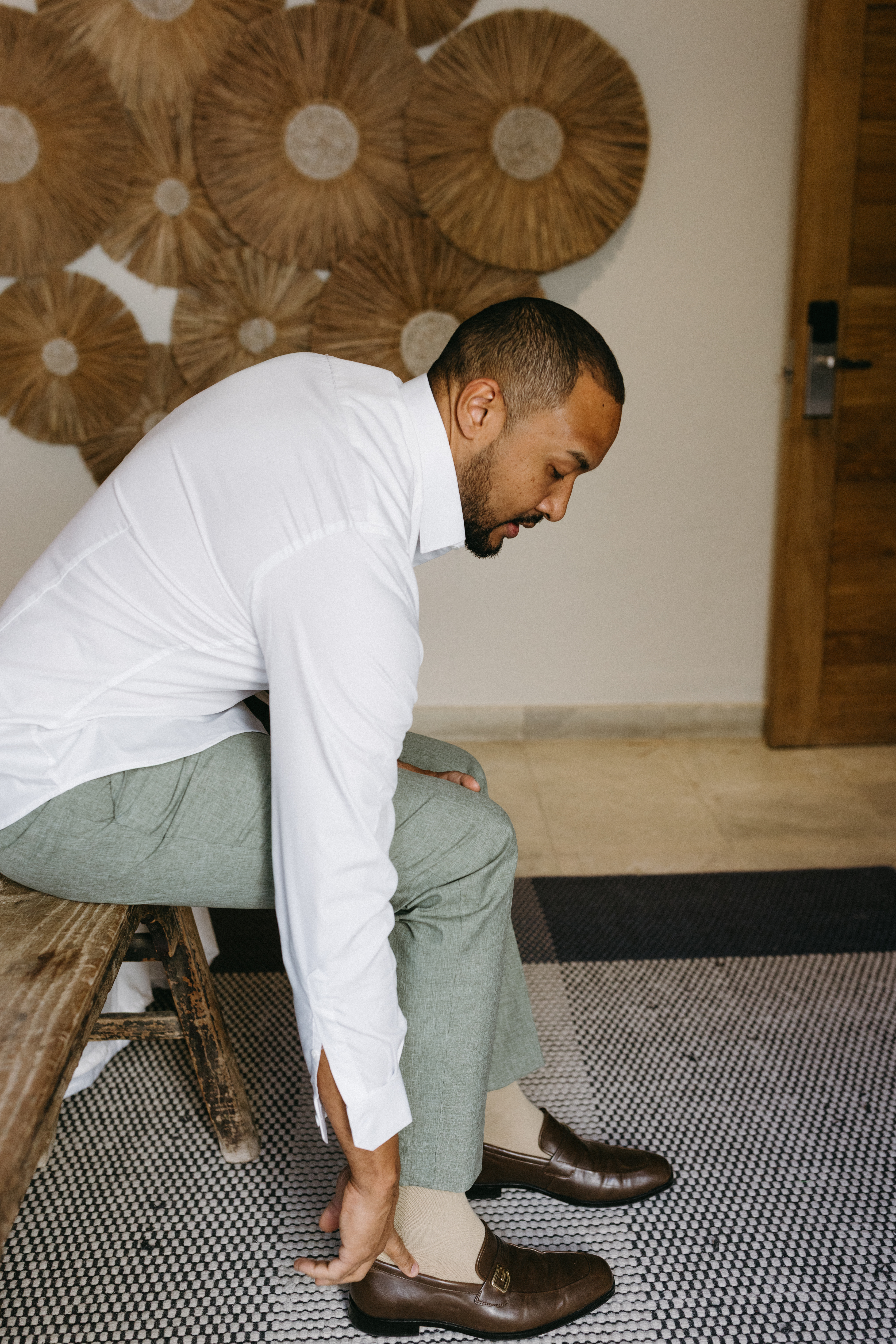 Groom adjusting his suit while spending time with family before the ceremony