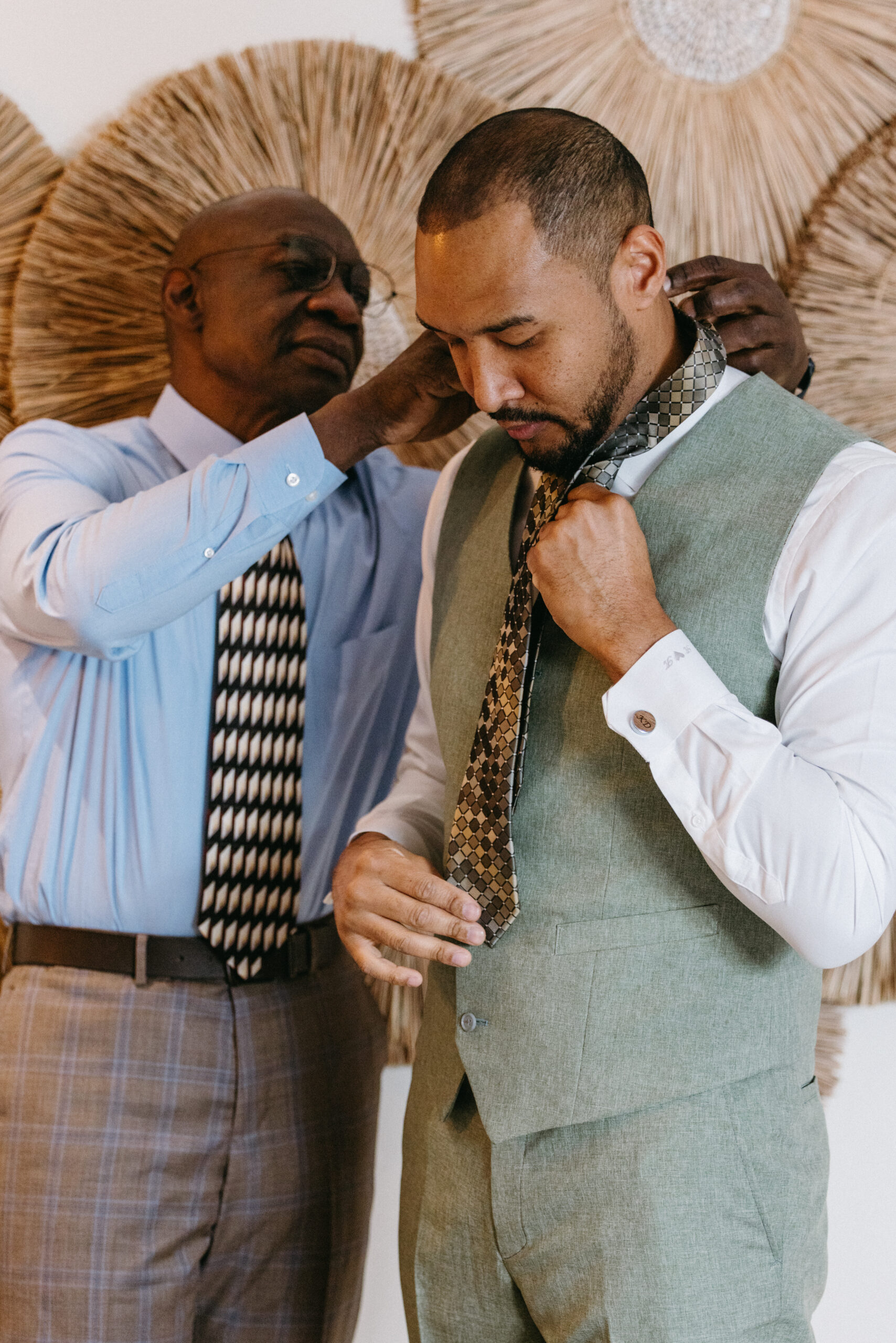 Groom adjusting his suit while spending time with family before the ceremony